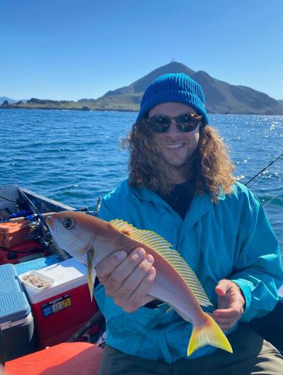 Dylan smiles with a fish he caught in a bay near ensenada