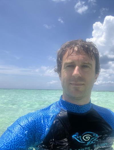 Stuart in a warm green water, adorning a rash guard