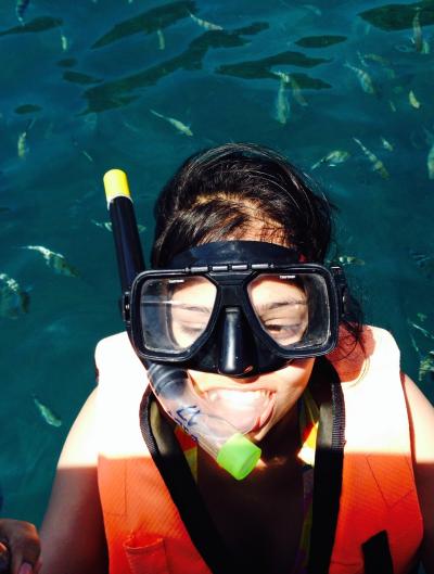 Tamhida jumping into the ocean with a snorkel, mask, and life vest on